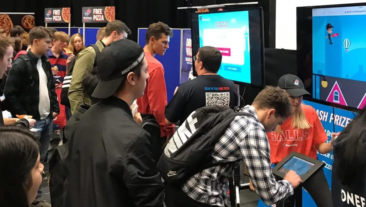 Trade Show Stand Visitors Playing Domino's Branded Game