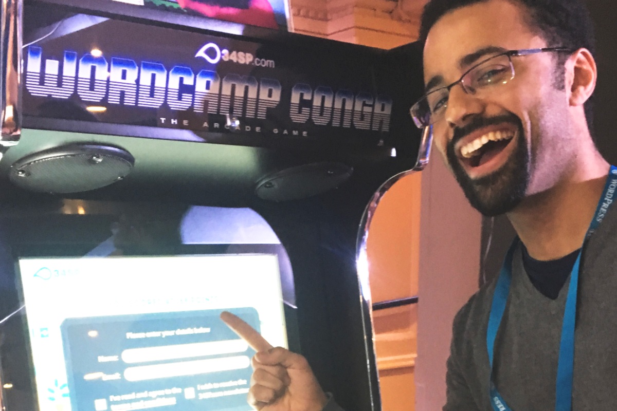 Player Pointing at Game Leaderboard on Arcade Machine