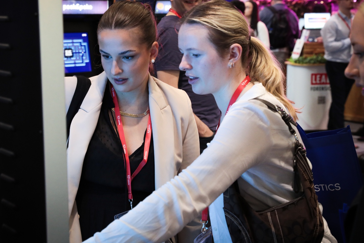 People Playing Digital Game on Large Touchscreen at Exhibition