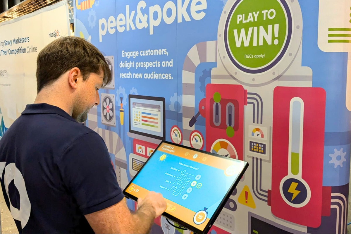 Person Playing Online Quiz Game on Touchscreen at Event